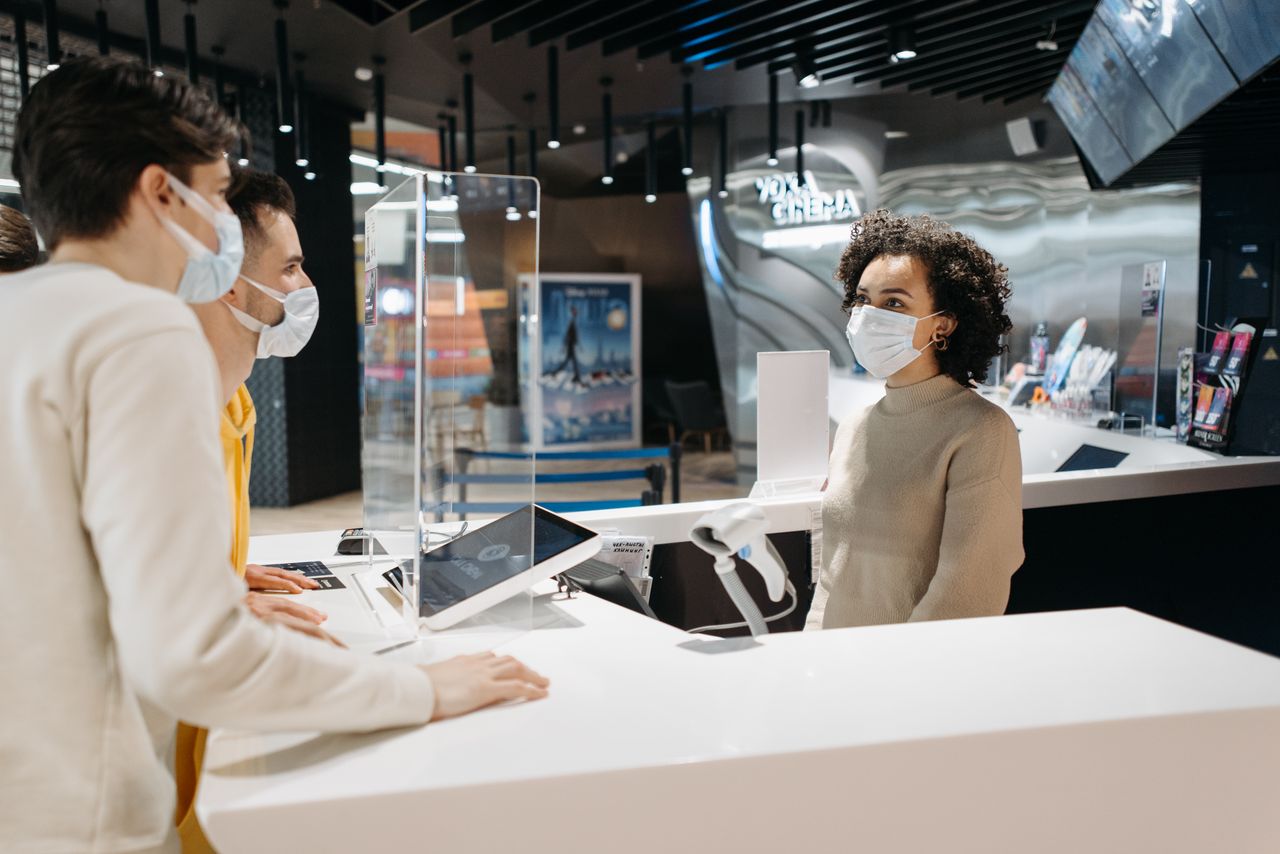 People at cinema counter wearing masks as part of new normal safety measures.